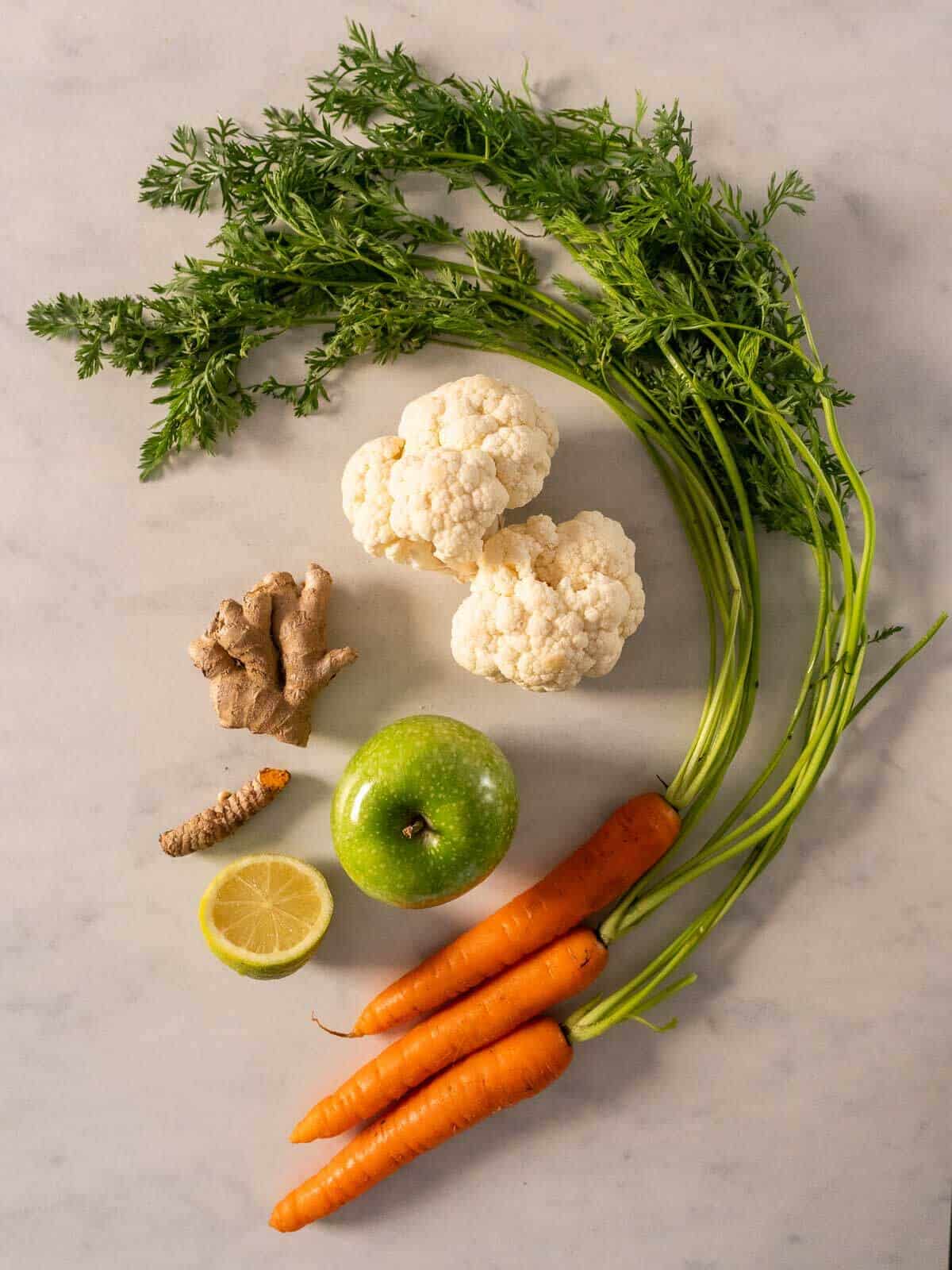 ingredients for the juice: carrots, cauliflower, apple, lemon, ginger and turmeric root.