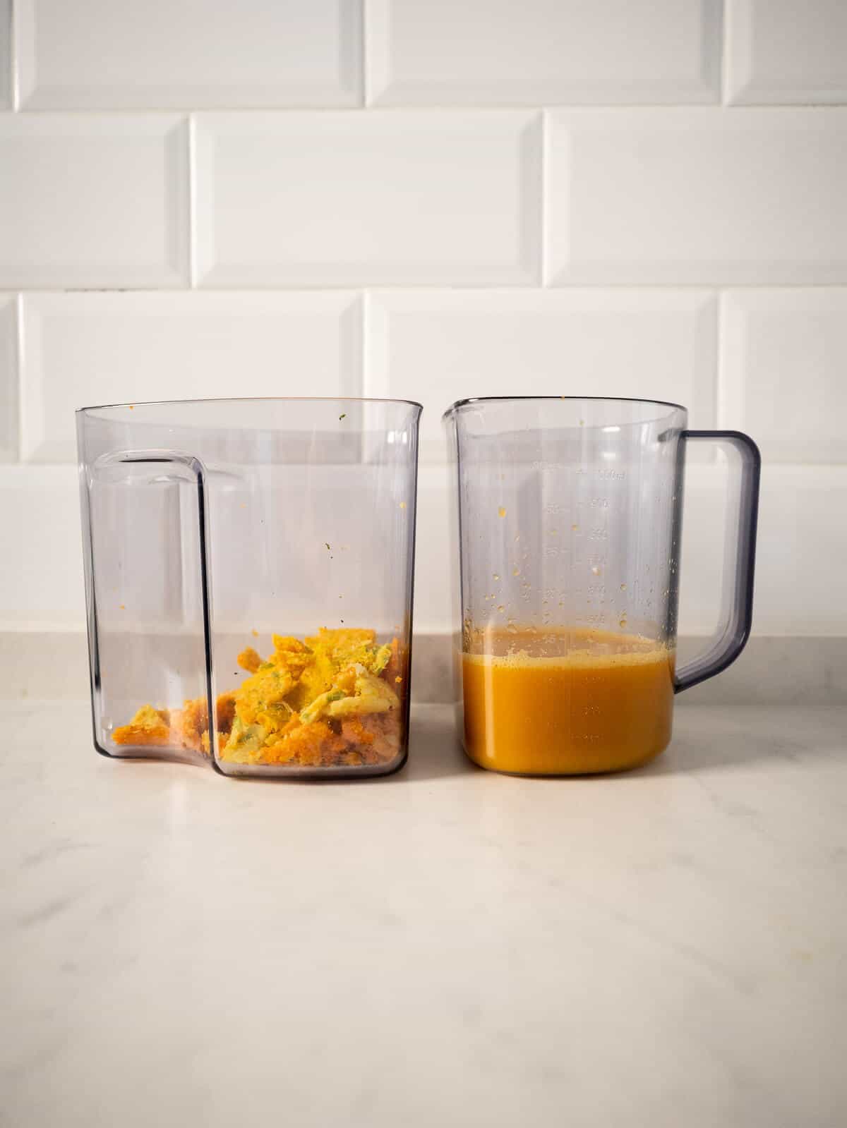 two jars from the juicer, one with carrot ginger turmeric juice, and the other one with a small amount of squeezed pulp.