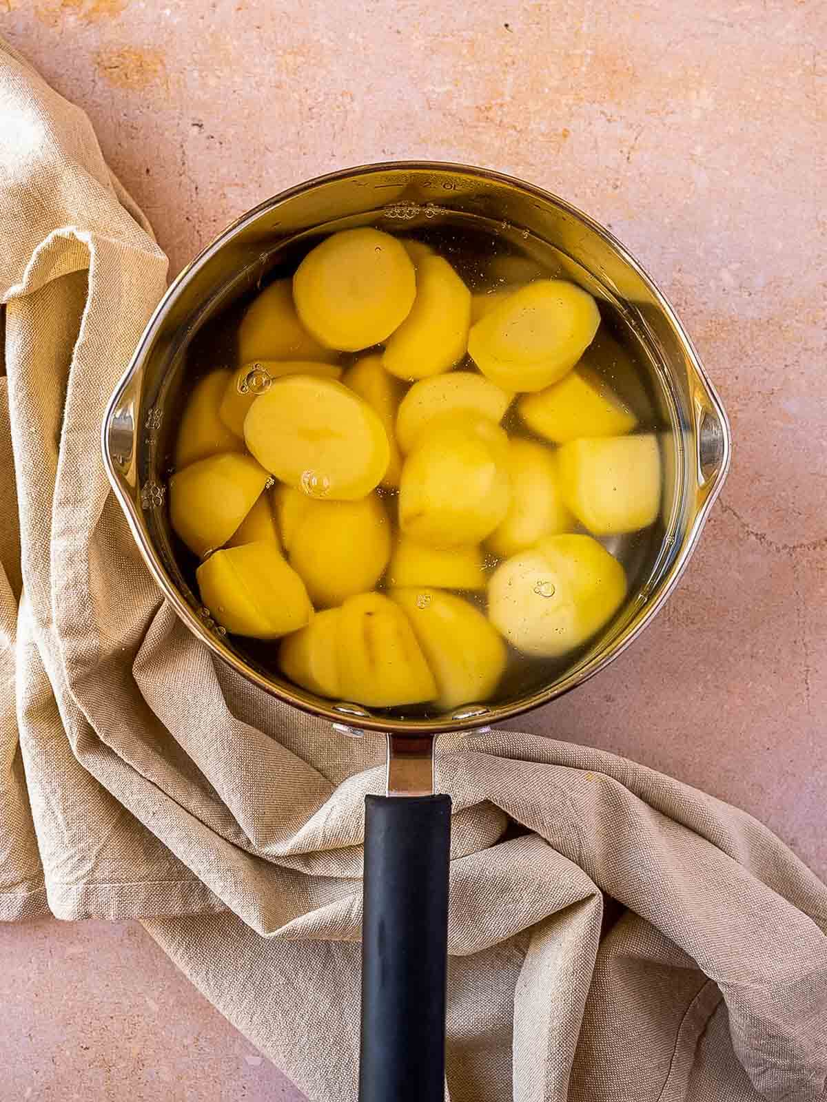 saucepan with potatoes boiling in salted water.