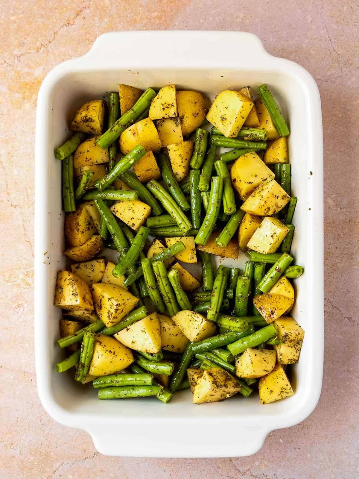 Tip the potatoes and green beans into a large casserole dish.