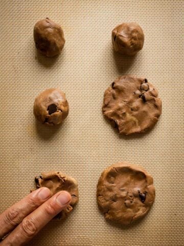 put the cookie dough balls on a baking sheet and press with your fingers.