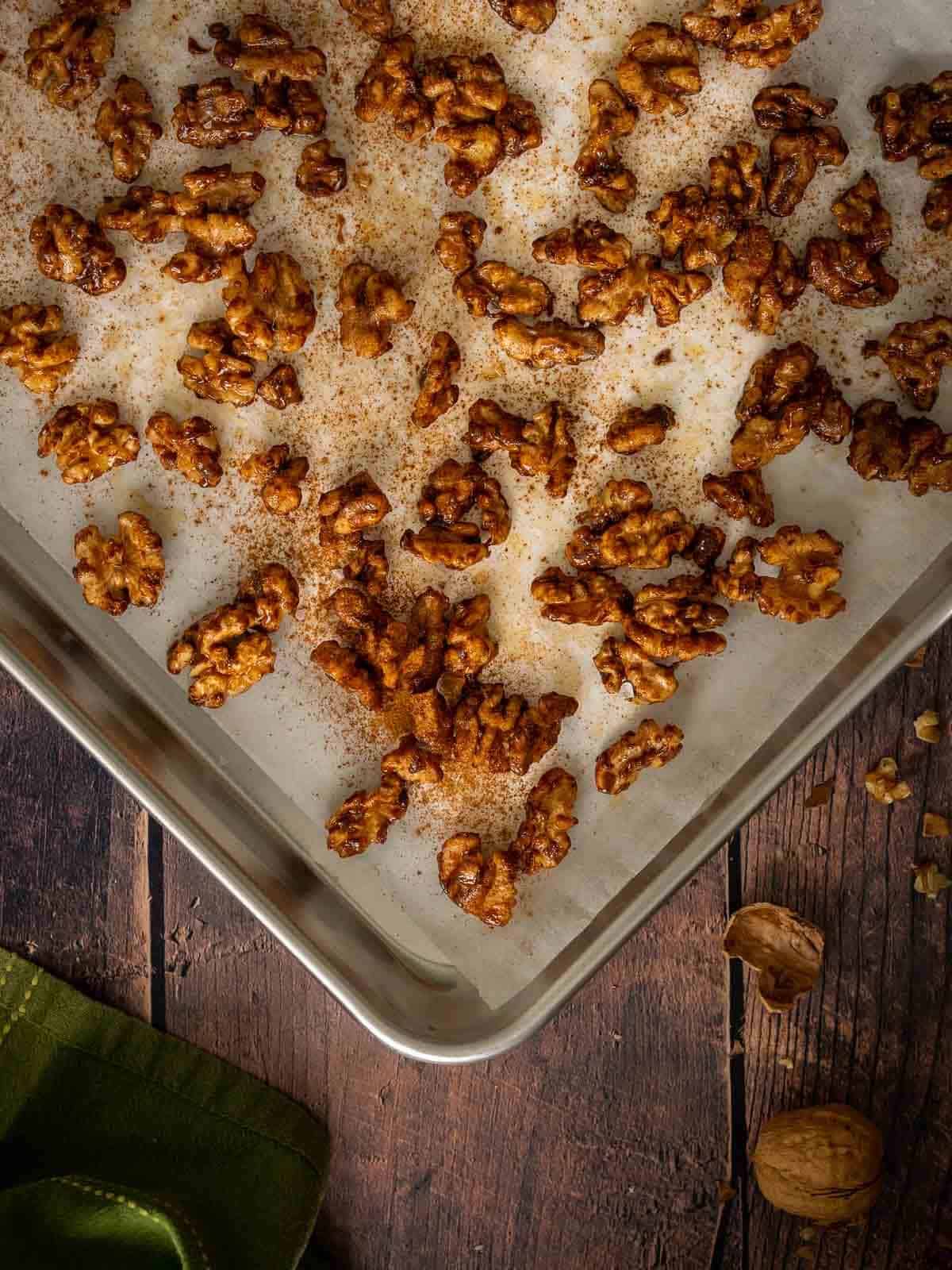 brown sugar candied walnuts in a baking tray with parchment paper.