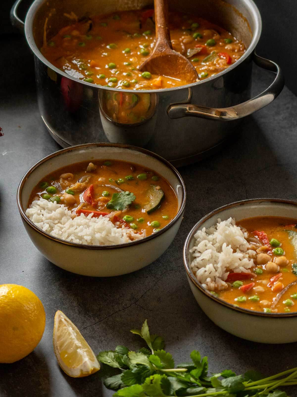 two bowl served next to a pot of vegan coconut chickpea curry.