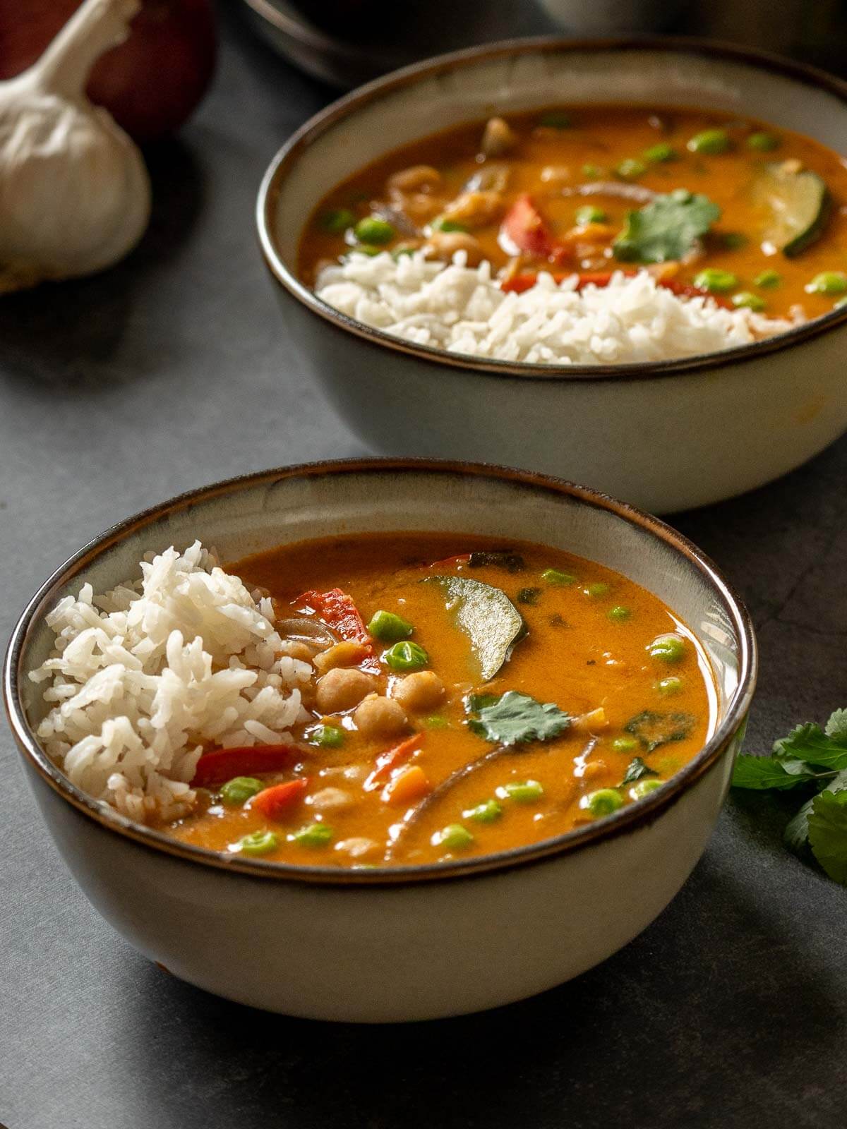 two bowls served with vegan coconut chickpea curry with steamed Jasmine rice.
