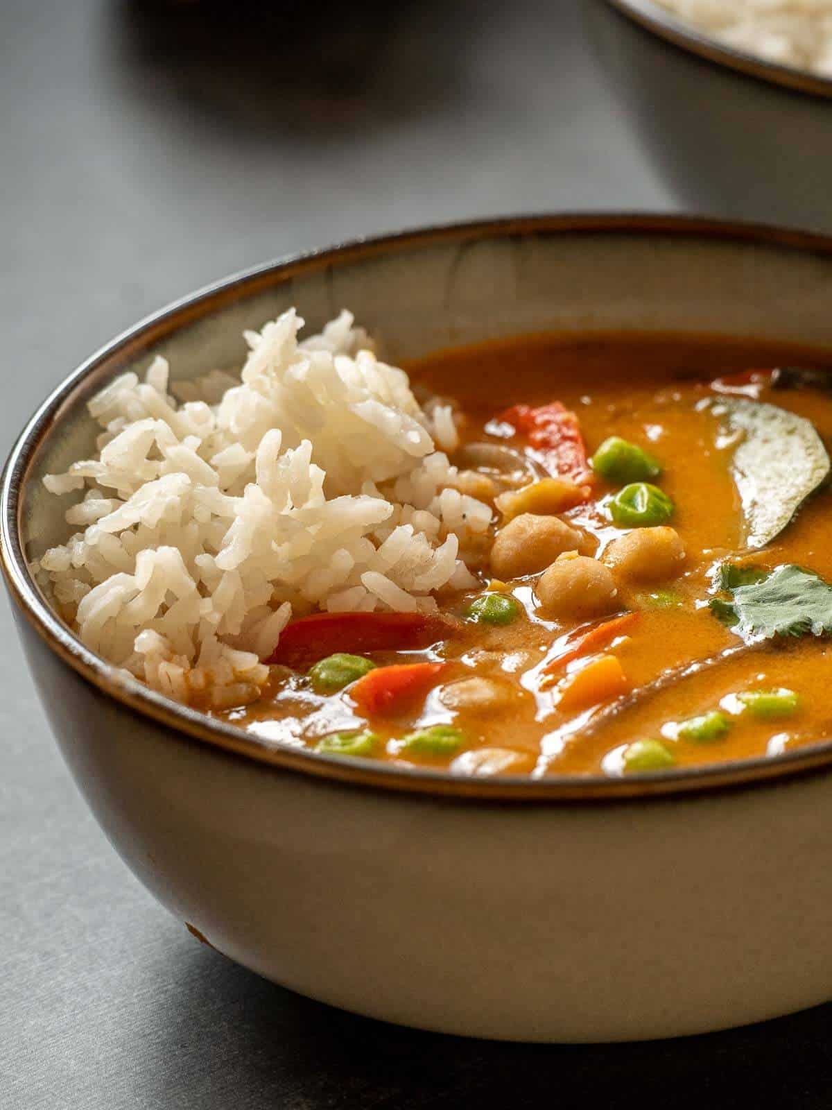small bowl served with vegan coconut chickpea curry with steamed Jasmine rice.