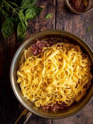 topping sautéd onions and garlic with fettuccine pasta al dente.