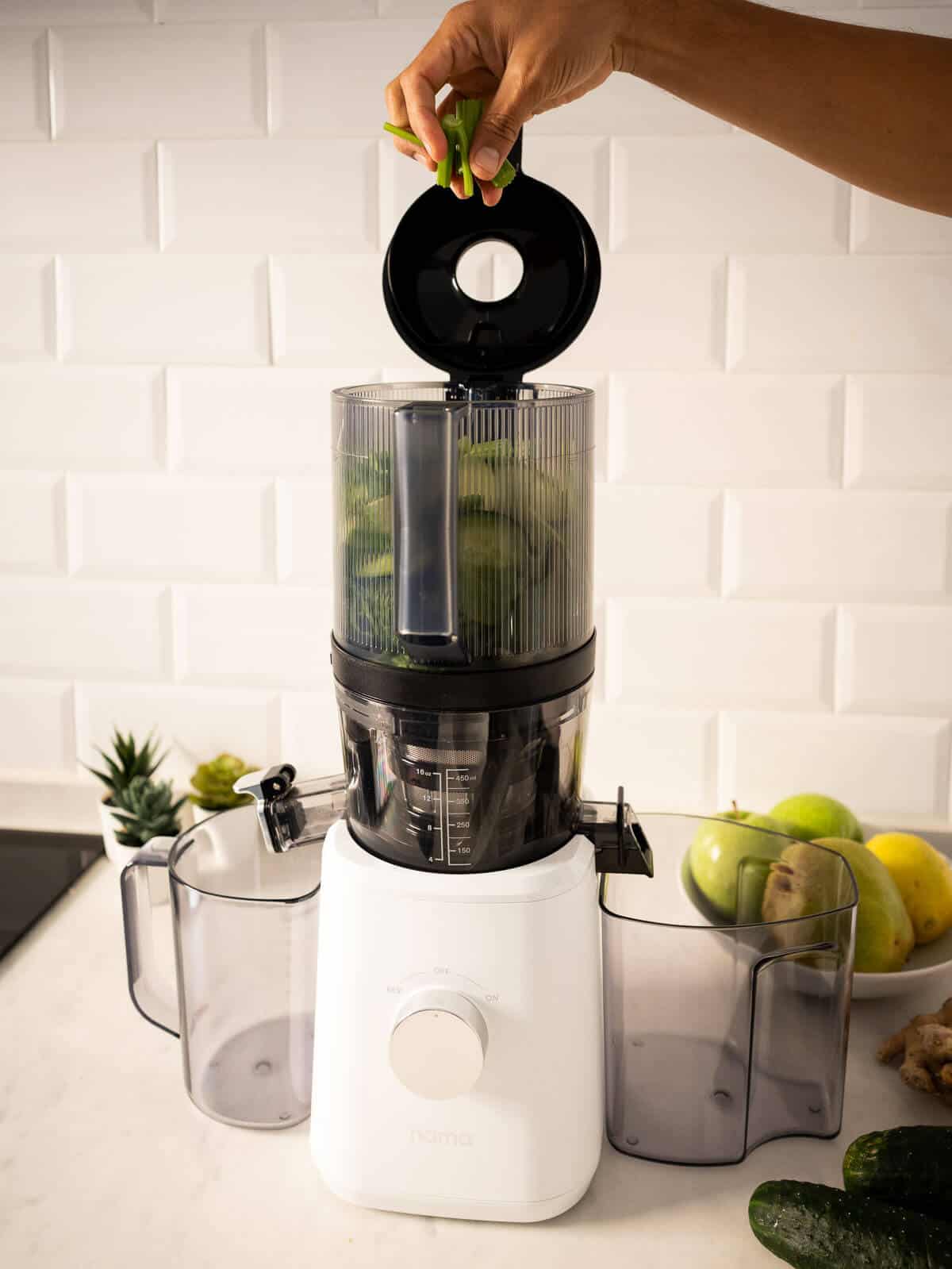 adding ingredients into the juicer.