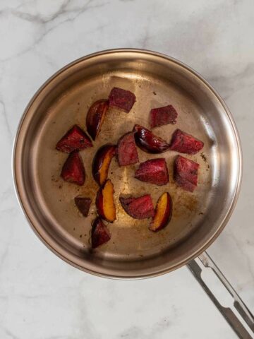 braise beets and plums with vegan butter in a saucepan.