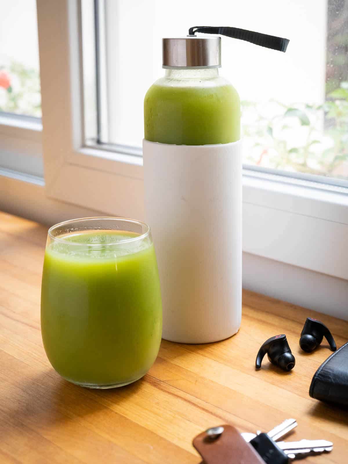 storing juice tips, three airtight glass containers with white silicon sheath and green juice glass.