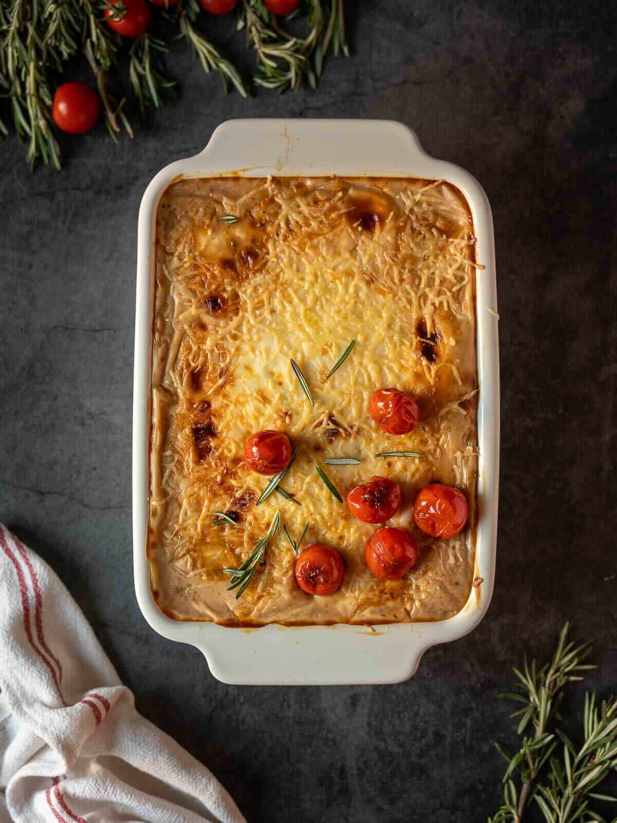 vegan vegetable casserole served with blistered cherry tomatoes.