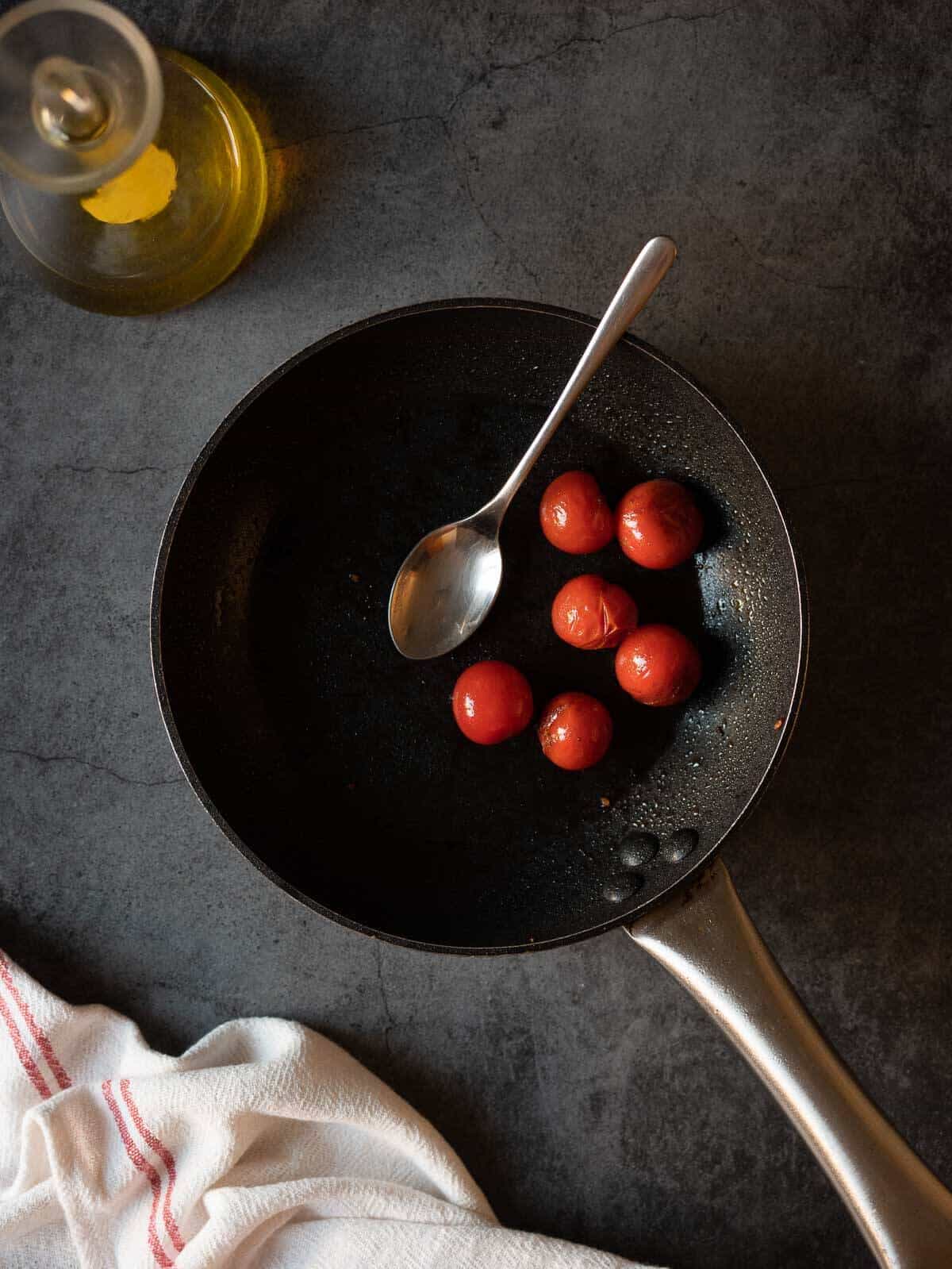 blistering cherry tomatoes on a skillet.