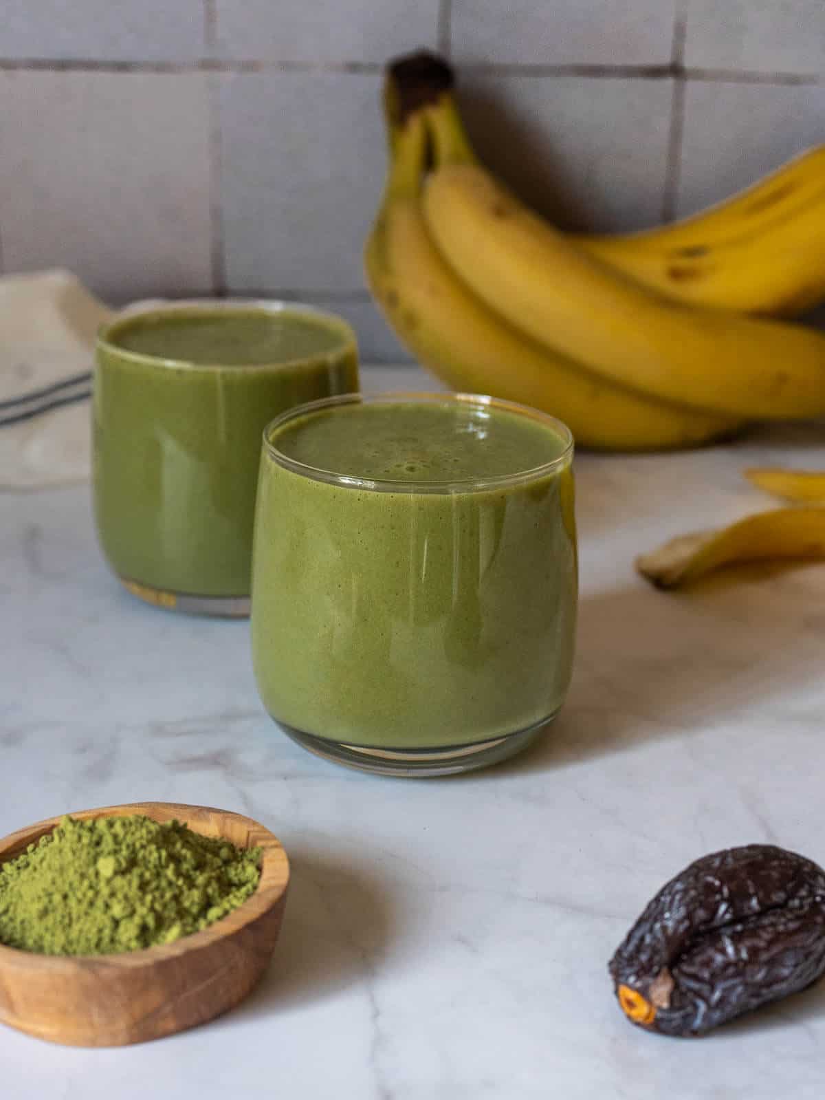 two glasses of energizing creamy banana matcha green tea smoothie.