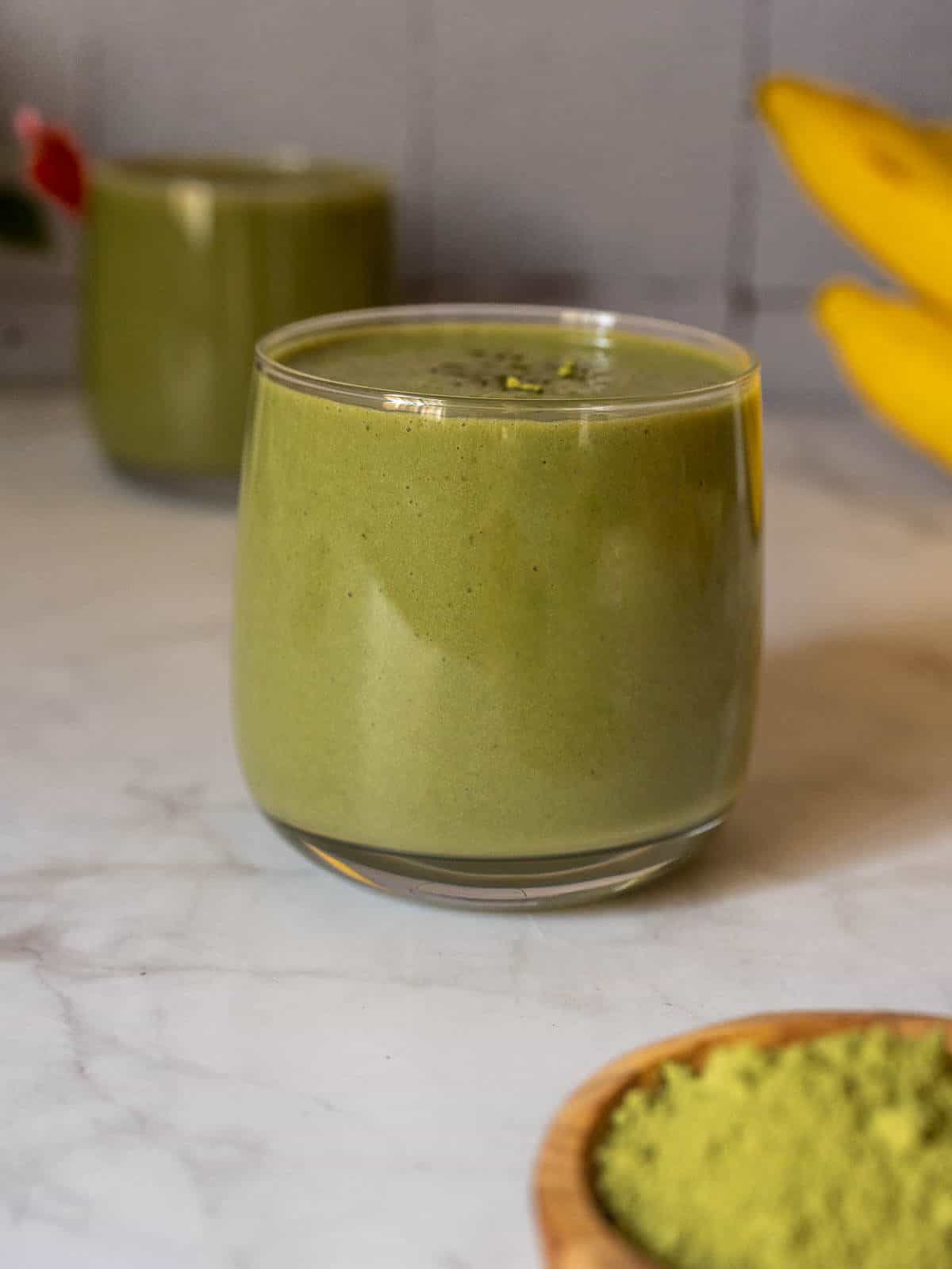 banana matcha smoothie served in a small glass.