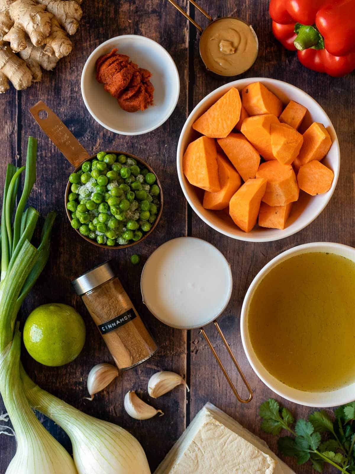 ingredients to make Thai massaman vegetable curry with tofu in a wooden table.