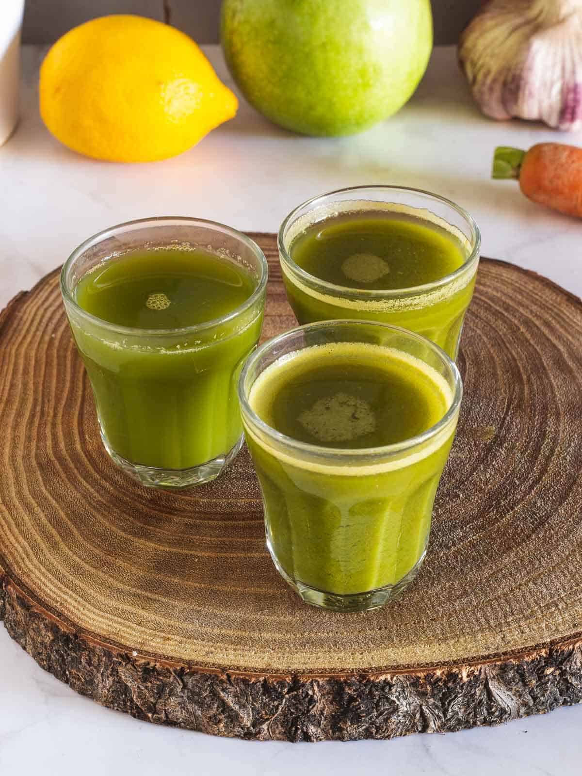 three apple lemon carrot spinach juice shots.