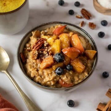 bowl of brown sugar cinnamon oatmeal next to a cup of golden milk, featured.