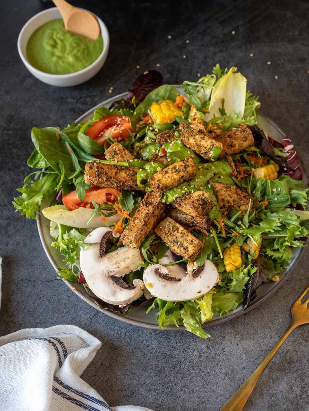 air fryer tofu served on top of a colorful salad bowl.