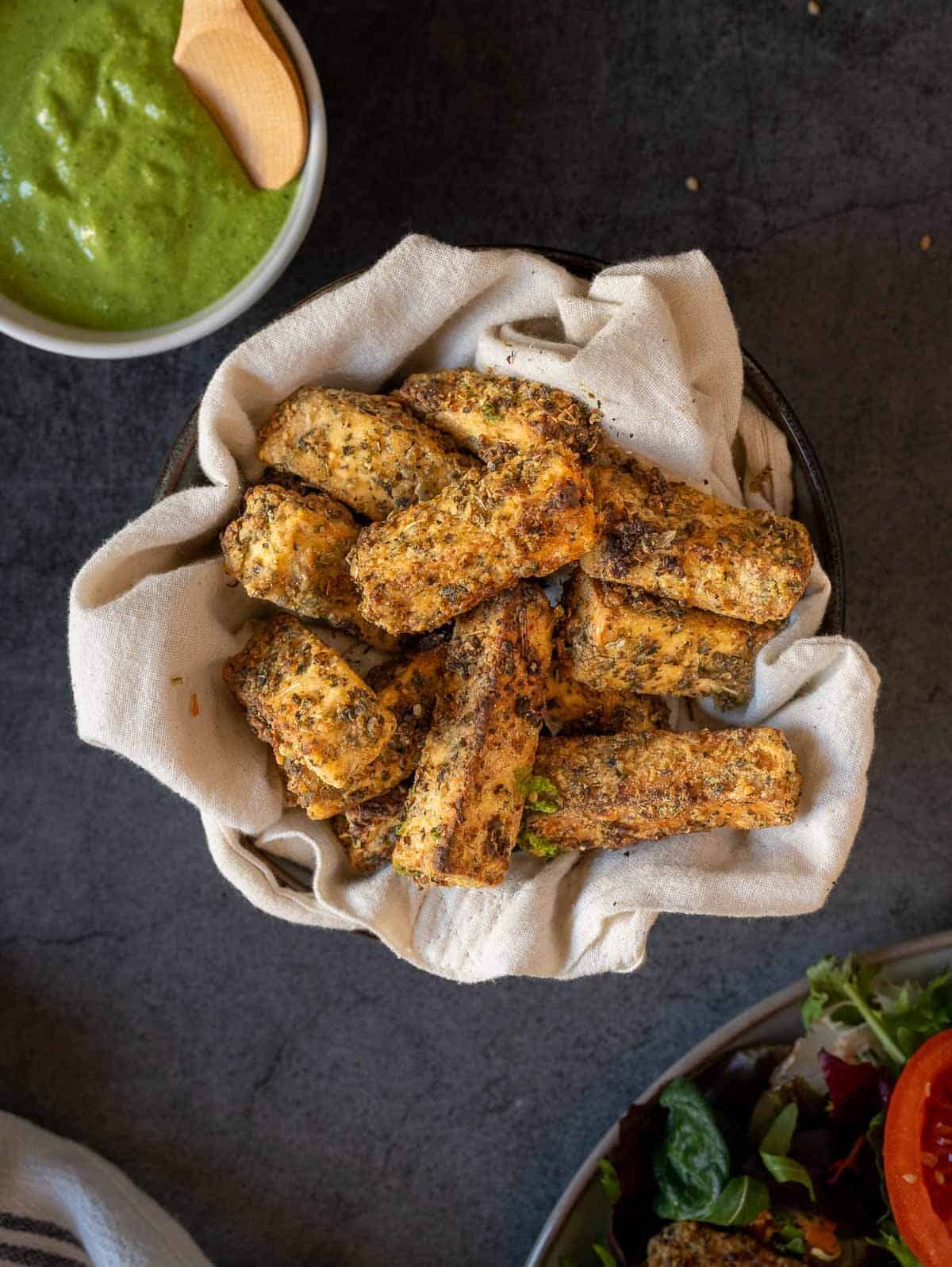 crispy tofu sticks with green creamy vegan sauce.