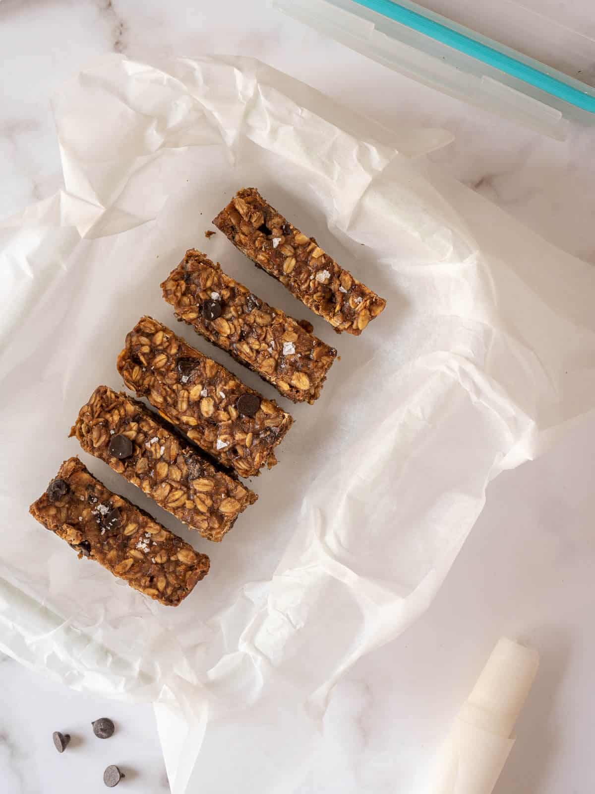 storing chocolate peanut butter oatmeal bars in airtight container with parchment paper.