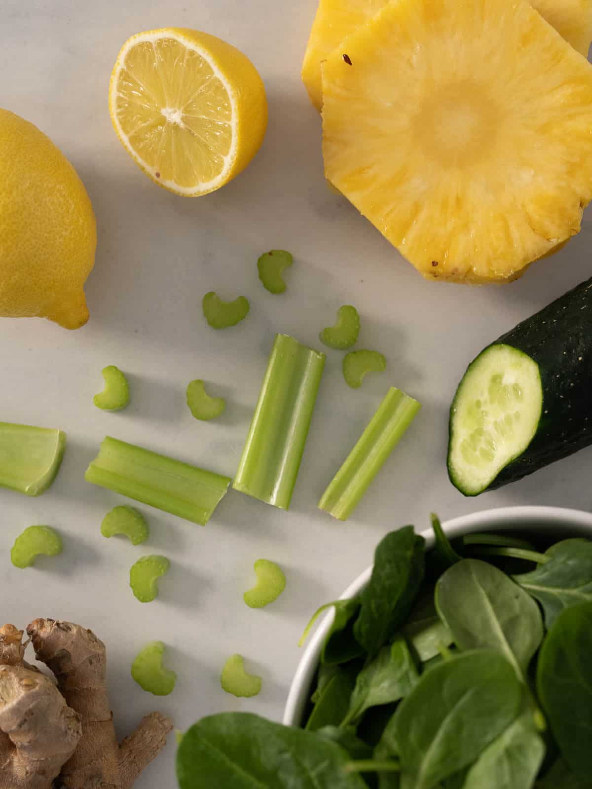 ingredients to make pineapple ginger juice with spinach and cucumber.