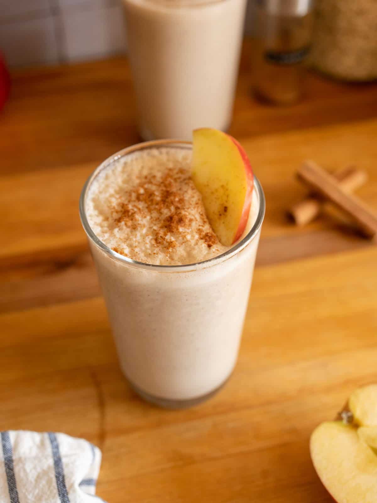 apple oatmeal smoothie topped with apple slice and ground cinnamon.