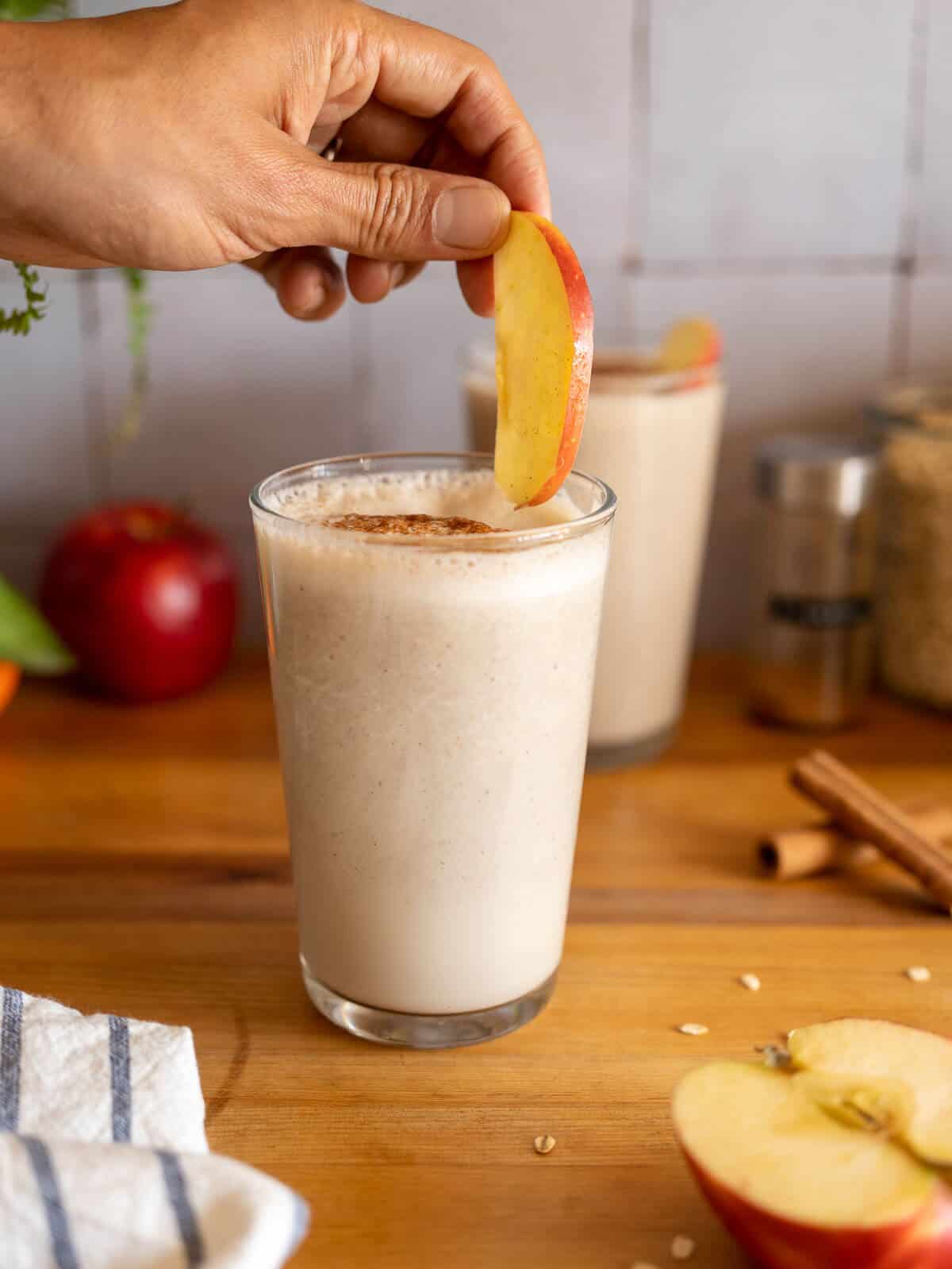 topping the apple cinnamon smoothie with an apple slice.