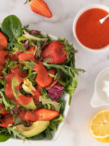 creamy strawberry balsamic dressing over a spinach and arugula salad featured.
