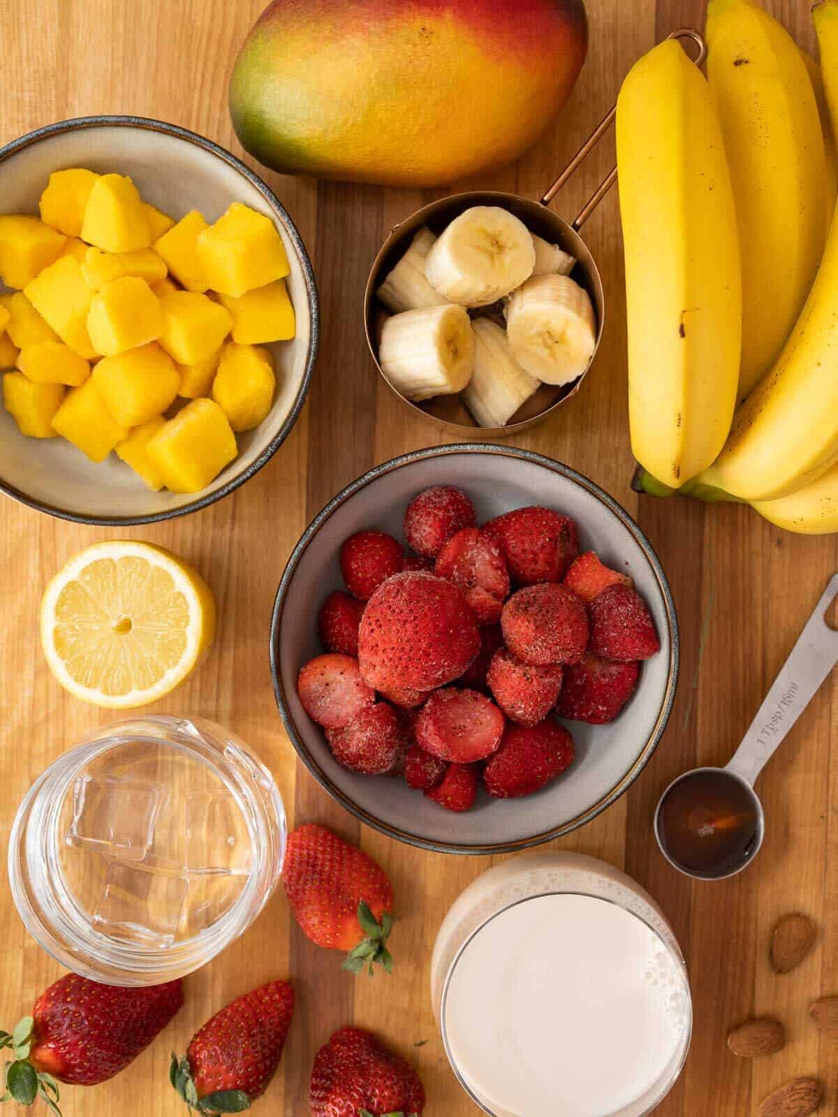 ingredients to make a strawberry banana mango smoothie.