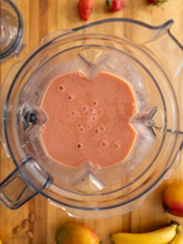 blending all the ingredients for the mango banana smoothie until creamy.