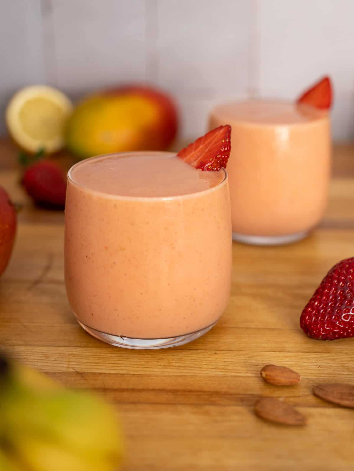 two glasses of strawberry banana mango smoothie.