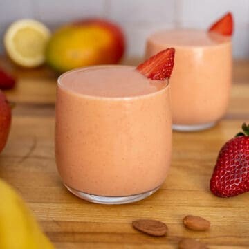 two glasses of strawberry banana mango smoothie featured.