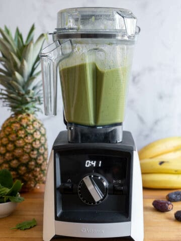 blending the ingredients of the pineapple spinach smoothie in a vitamix high-speed blender.