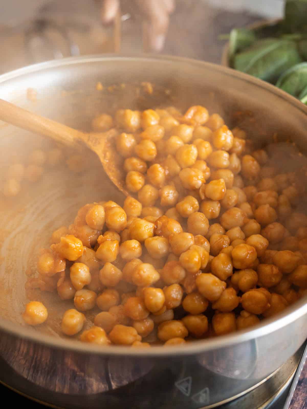 stirring chickpeas with garlic and spices.