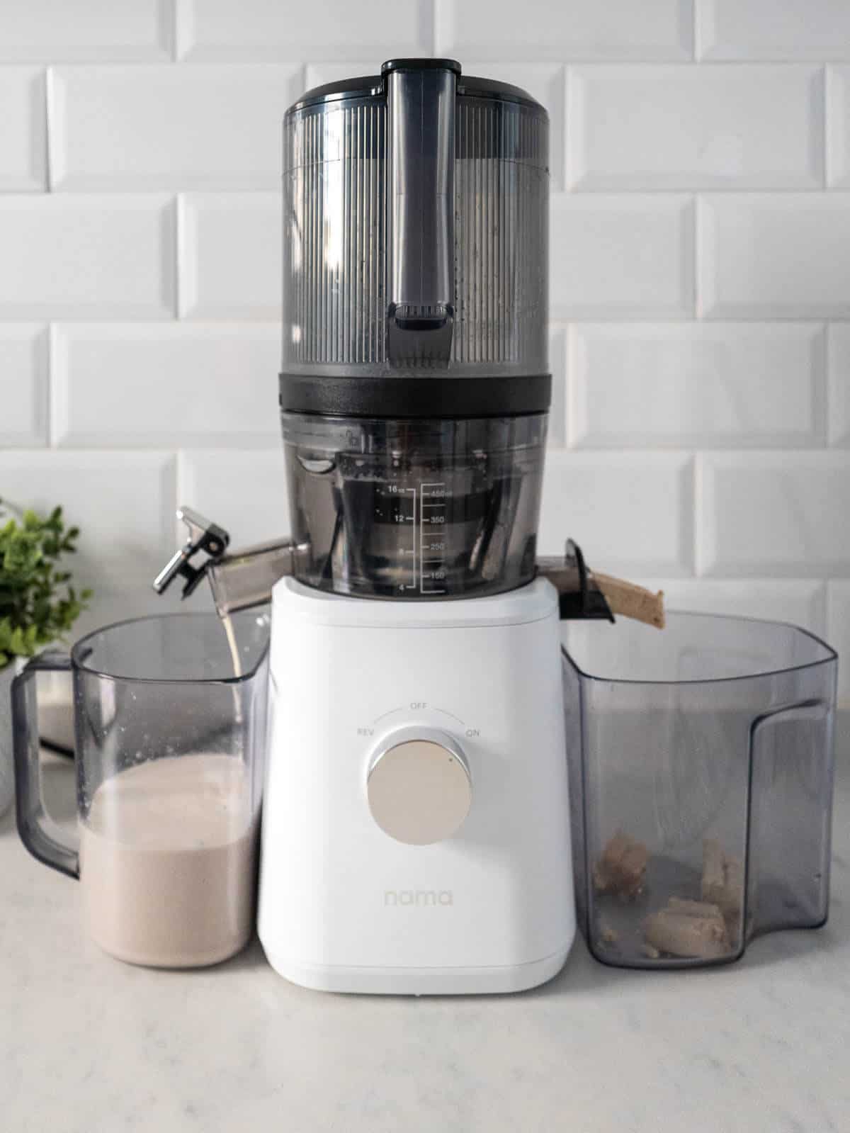 Nama J2 juicer with cashew milk and pulp.