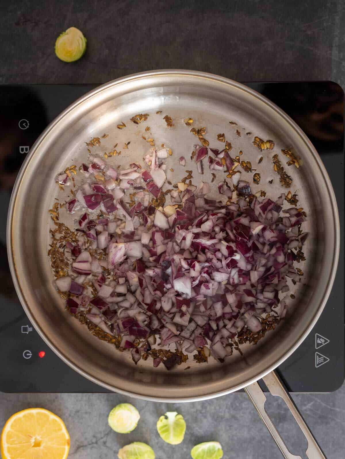 adding garlic and onions to the saucepan.