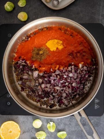 adding tomato sauce and the rest of the spices to the saucepan.