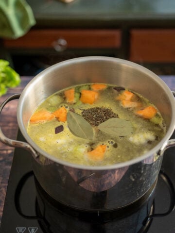large saucepan with vegetable broth poured over the peas and stir-fried vegetables.