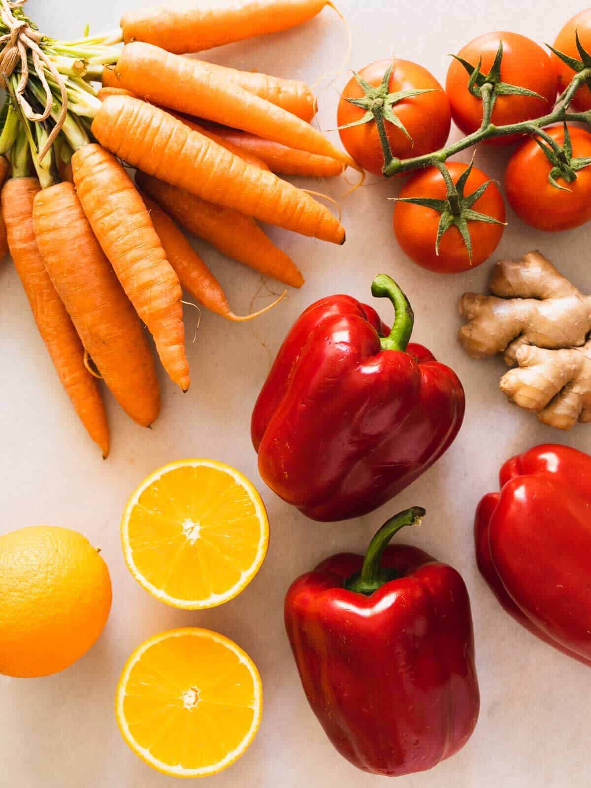 Ingredients to make red bell pepper juice on a white table.