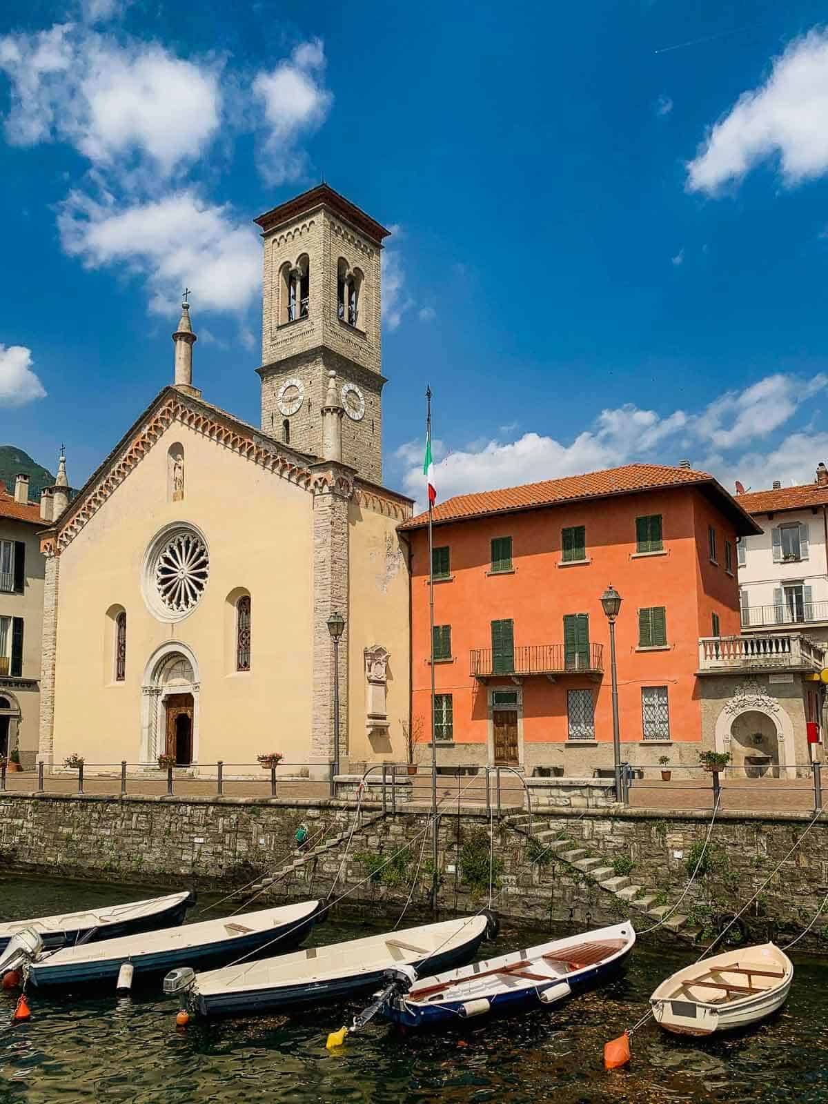 chapel in front of the sea and anchoring boats in Torno, Lake Como.