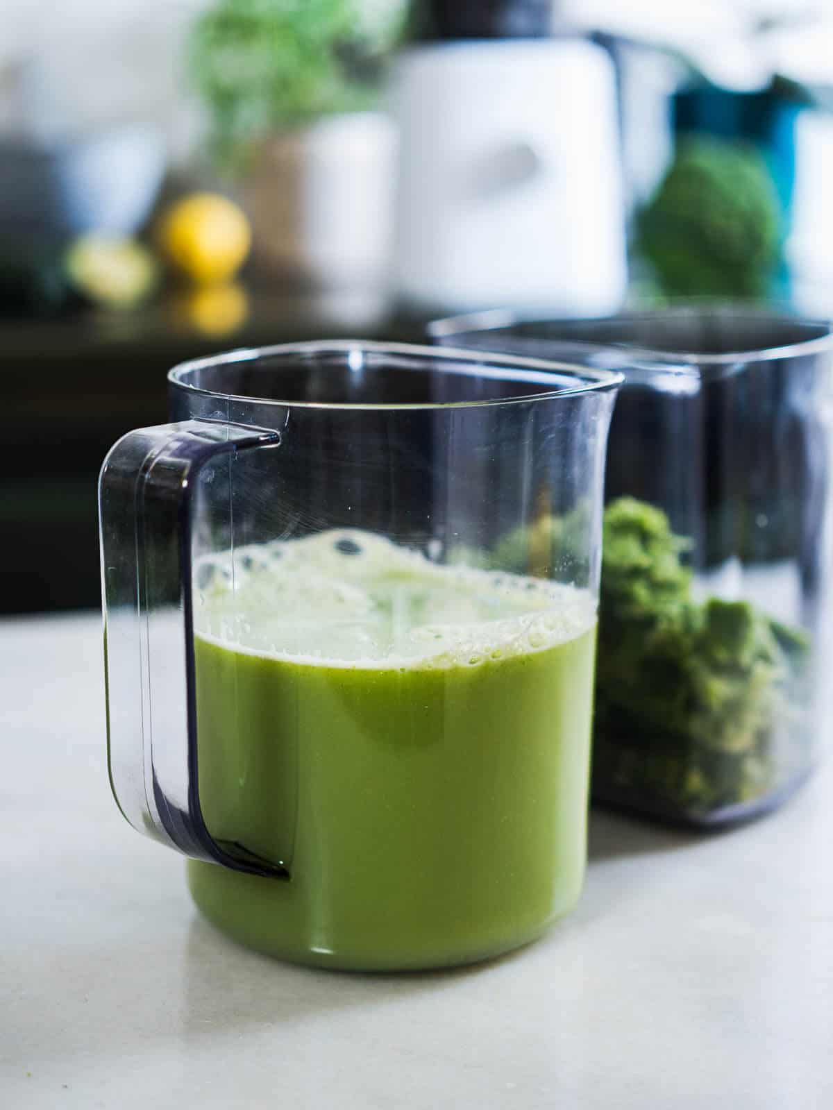 two separate jars, one with broccoli juice and the other with green reusable pulp.