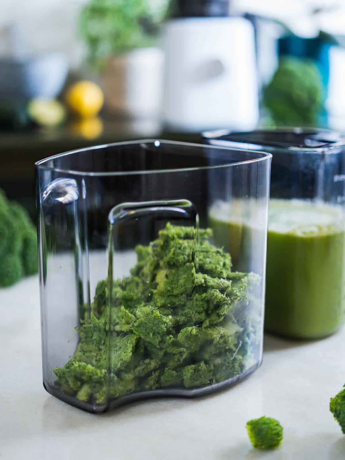 two separate jars, one with broccoli juice and the other with green reusable pulp.