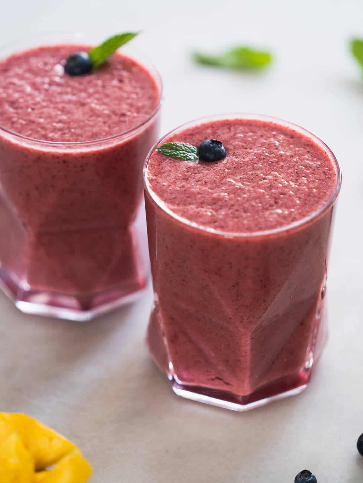 Pineapple Blueberry Juice served with blueberries and mint leaves on top.