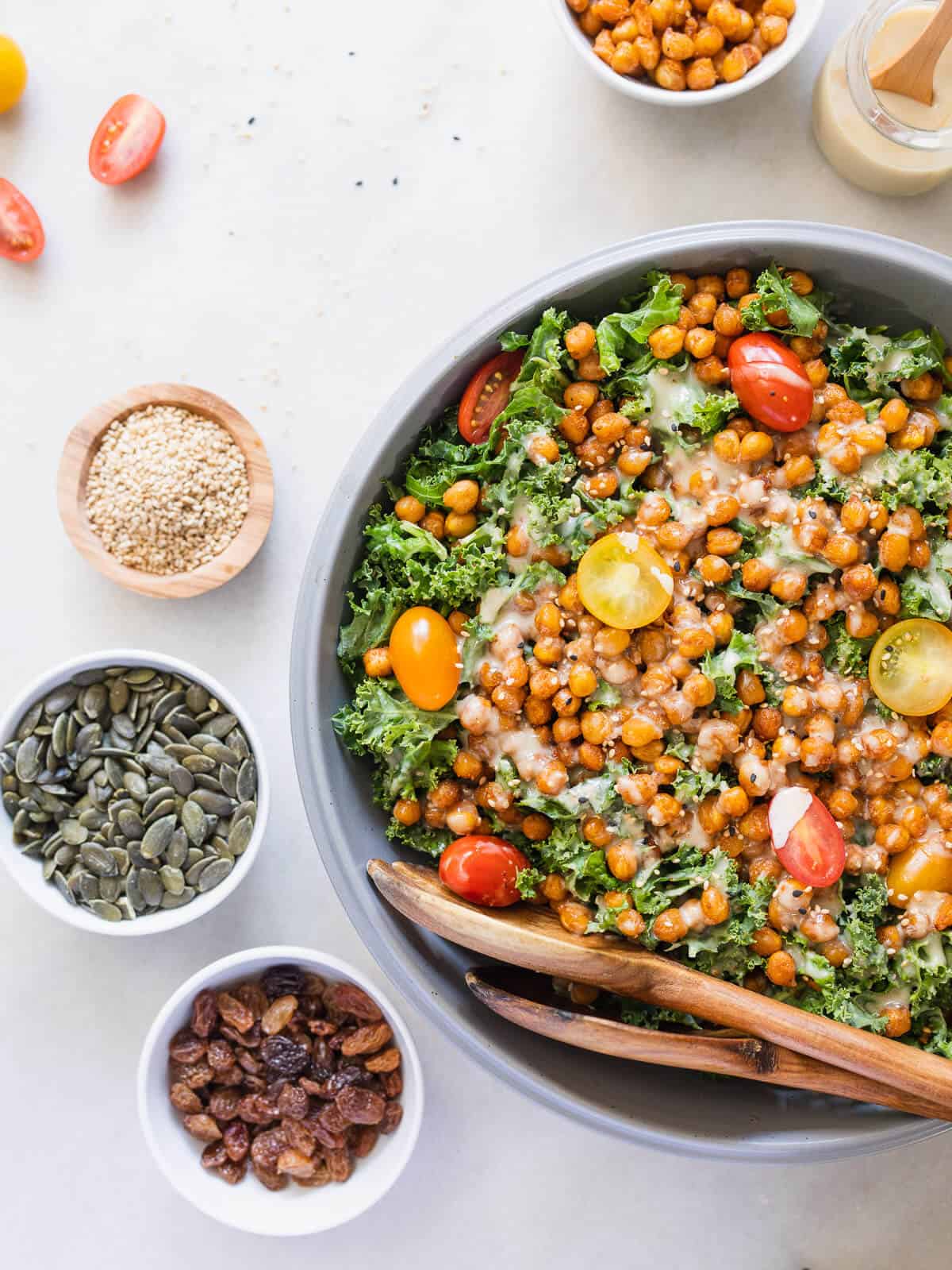 crispy chickpea kale salad with tahini dressing optional add ins in small bowls.