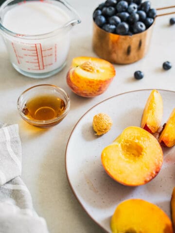 cored peaches with the rest of ingredients to make a blueberry peach smoothie.