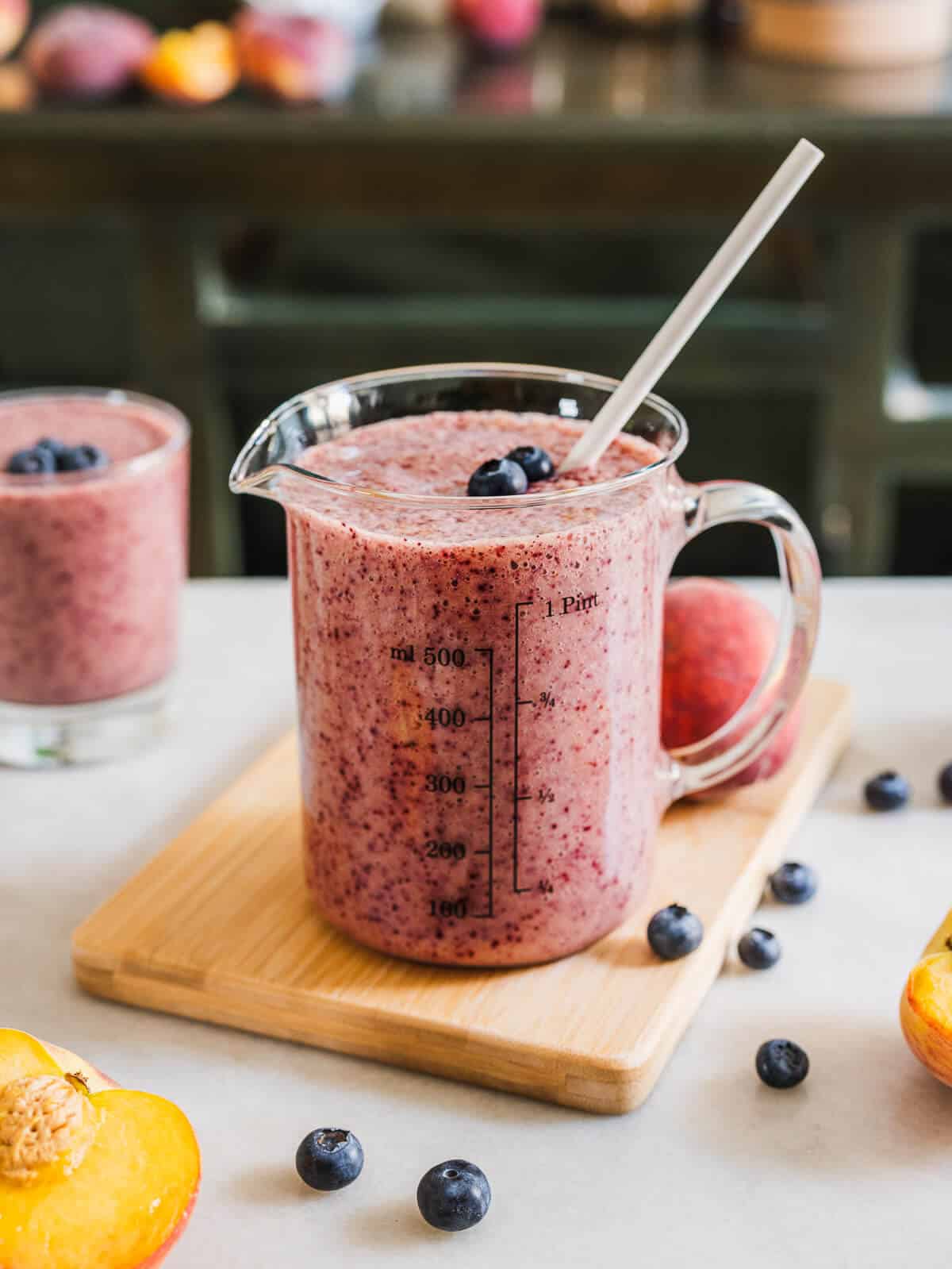 glass of smoothie garnished with fresh blueberries.