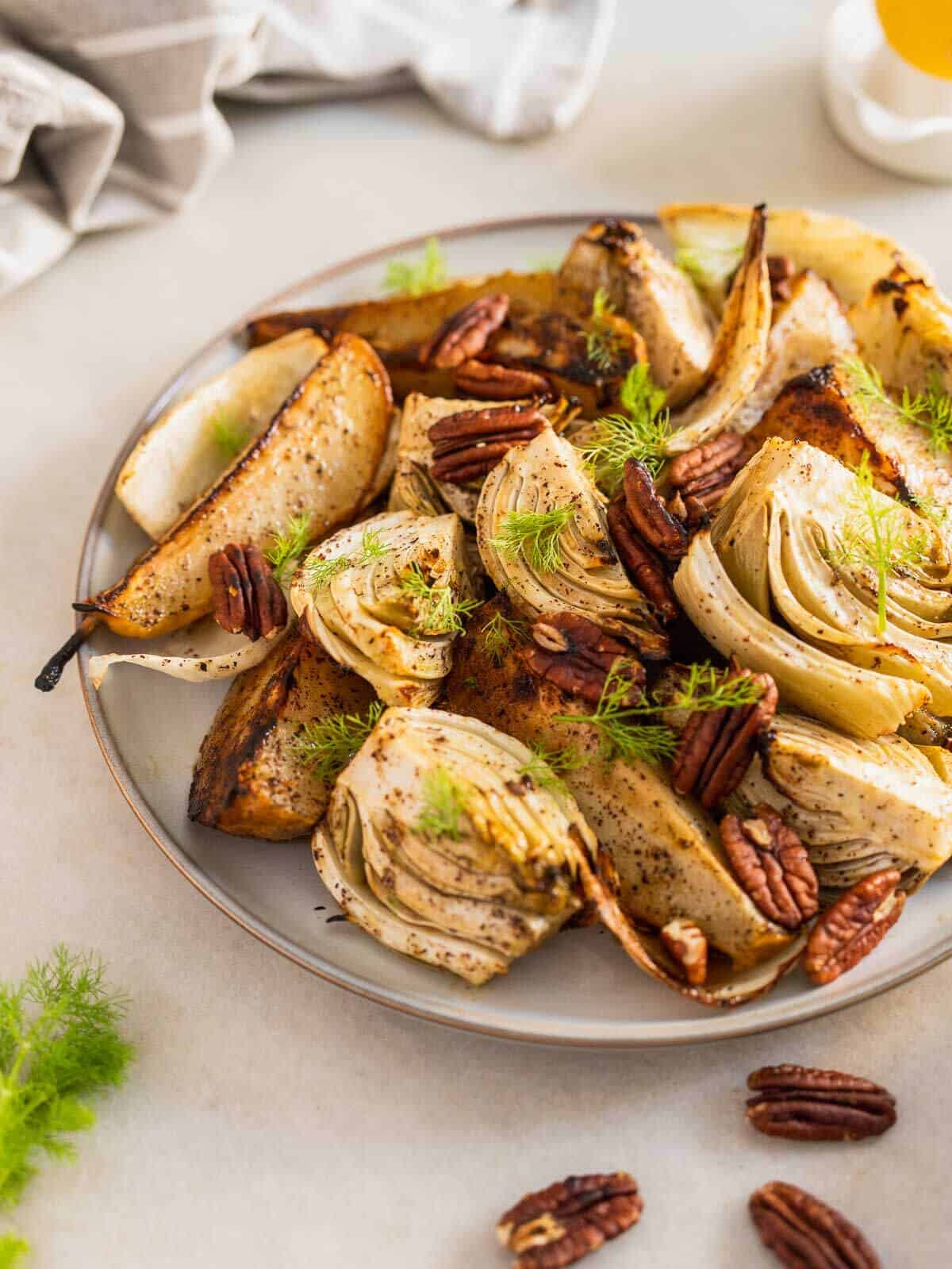 roasted pear and fennel salad with pecan nuts in serving plate.