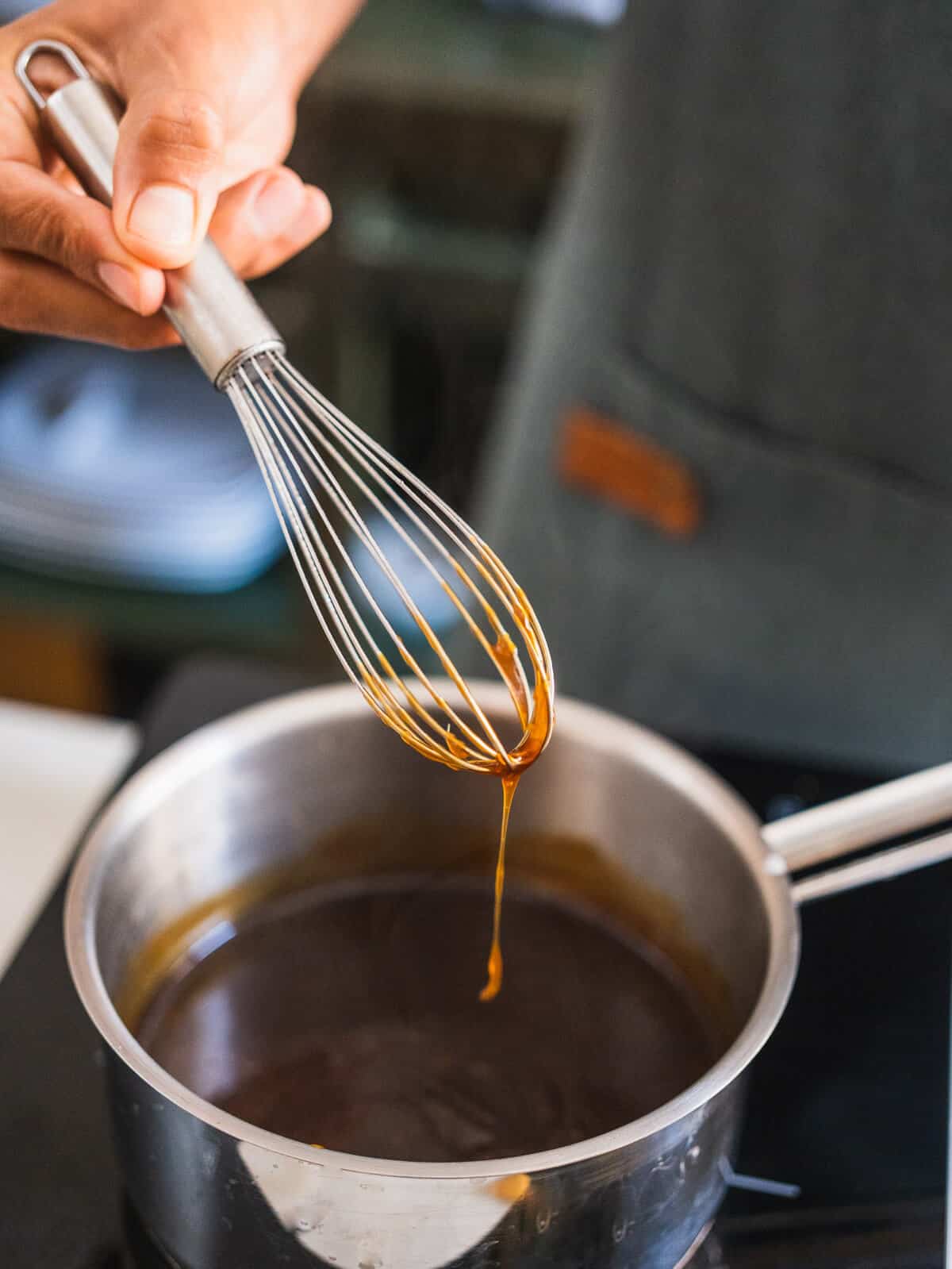 showing texture with a whisk with thickened teriyaki sauce .