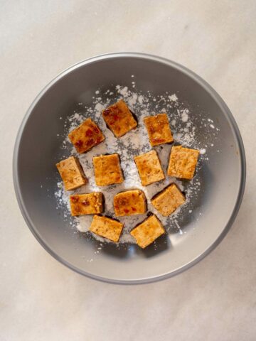 Coat the marinated tofu in cornstarch in a flat pan.