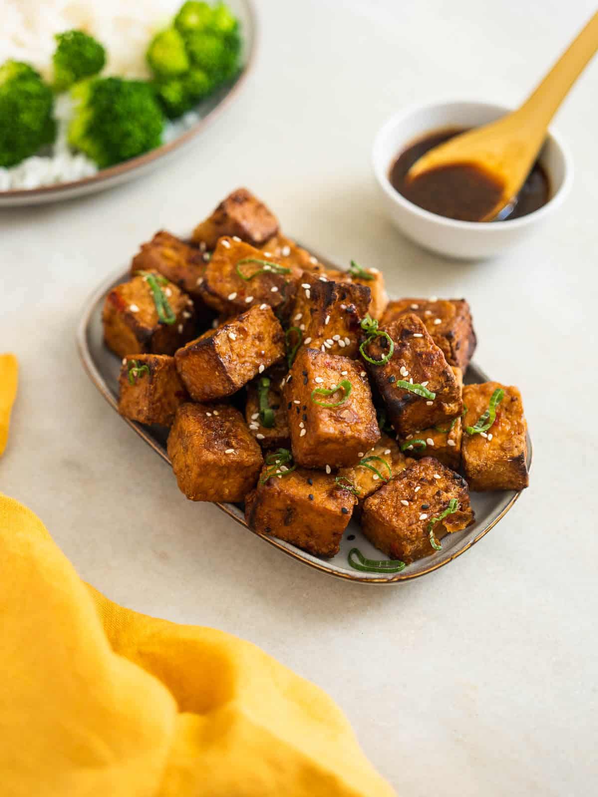 crispy teriyaki tofu puffs with steamed broccoli florets.