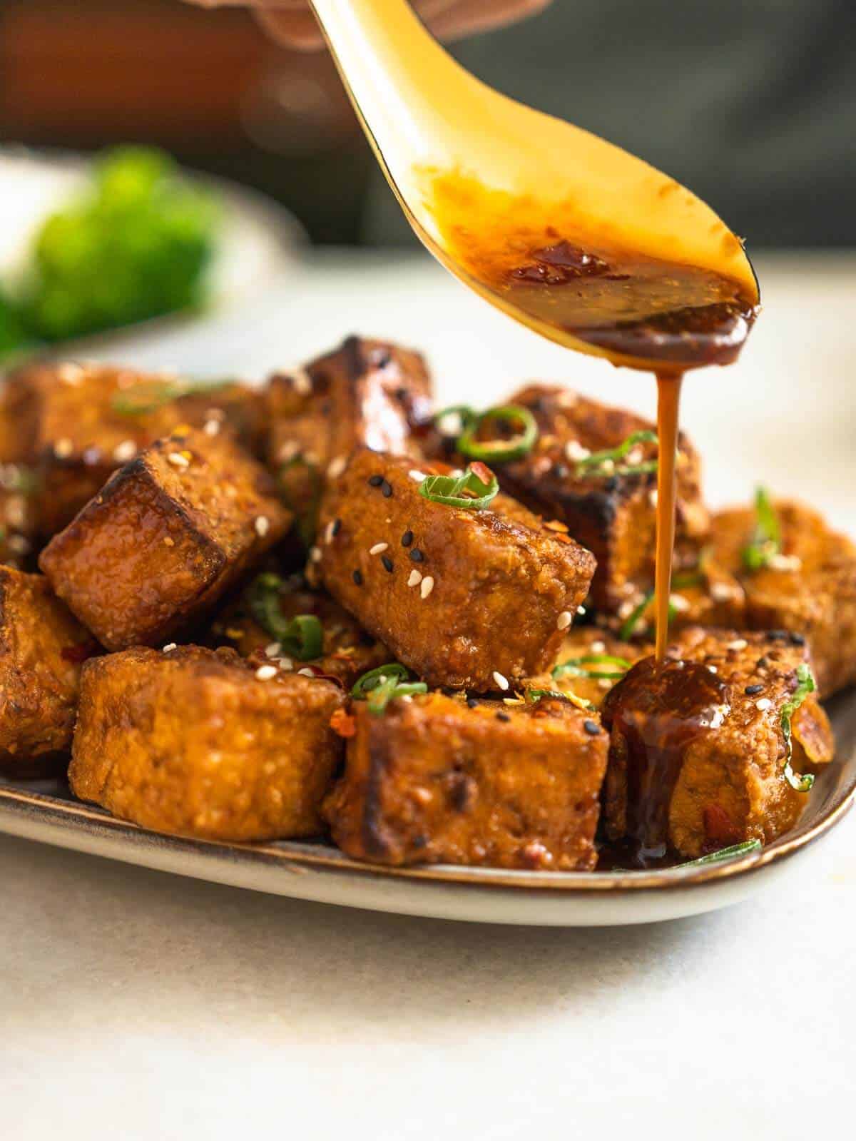 adding tofu marinade on top of the tofu puffs.